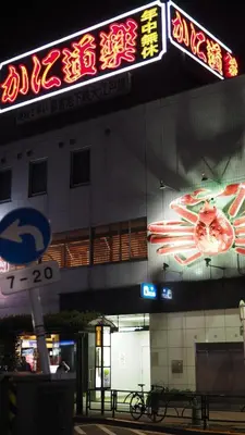 a building with neon signs on the side of it at 103 3-minute walk to Nishi-Shinjuku 5-chome Station in Tokyo