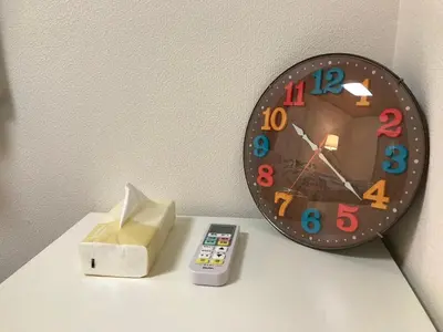 a clock and a remote control on a table at Shibuya Star 101 4 mins to Shinjuku Free WiFi in Tokyo
