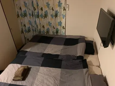 a bedroom with a bed with a tv on the wall at Shibuya Star 102-4 mins to Shinjuku-Free WiFi in Tokyo