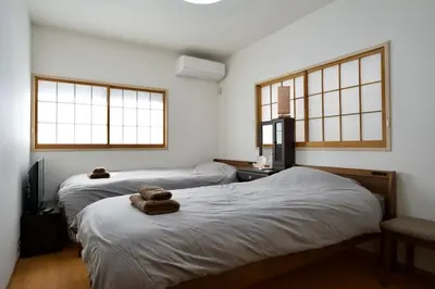 a room with two beds and two windows at Ueno Hoshi-5 minutes from Iriya Station-1 stop from Ueno station in Tokyo