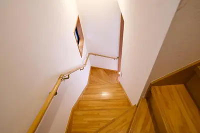 a hallway with a staircase with wooden floors and white walls at Ueno Hoshi-5 minutes from Iriya Station-1 stop from Ueno station in Tokyo