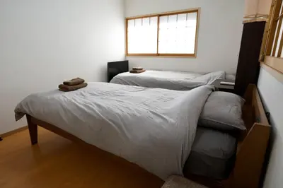 two twin beds in a room with a window at Ueno Hoshi-5 minutes from Iriya Station-1 stop from Ueno station in Tokyo