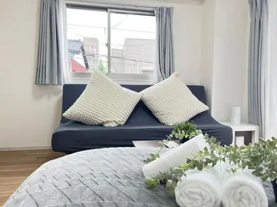 a blue couch with pillows in a living room at Ikebukuro Area 2F5 NishiikeApartment in Tokyo