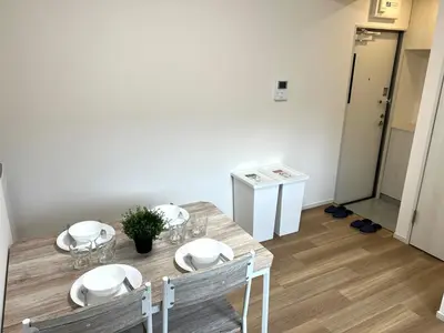a dining room with a wooden table with four chairs at Ikebukuro Area 2F5 NishiikeApartment in Tokyo