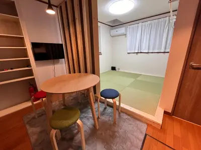a small table and two stools in a room at \u306b\u3058\u3044\u308d\u90b8\u6771\u4eac\u5927\u5cf6\u99c5\u524d in Tokyo