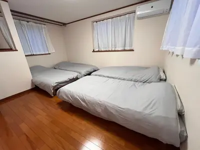 two beds in a room with two windows at \u306b\u3058\u3044\u308d\u90b8\u6771\u4eac\u5927\u5cf6\u99c5\u524d in Tokyo