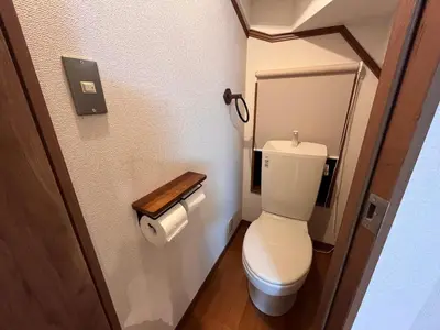 a small bathroom with a toilet and a toilet paper dispenser at \u306b\u3058\u3044\u308d\u90b8\u6771\u4eac\u5927\u5cf6\u99c5\u524d in Tokyo