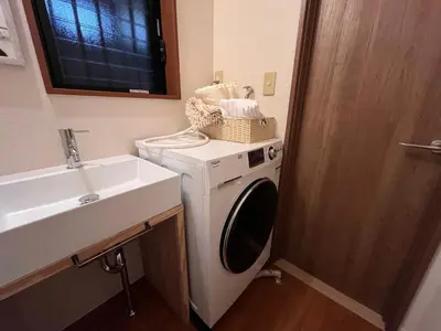 a bathroom with a washing machine and a sink at \u306b\u3058\u3044\u308d\u90b8\u6771\u4eac\u5927\u5cf6\u99c5\u524d in Tokyo