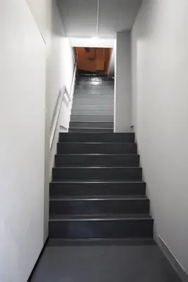 a staircase in an office building with black stairs at BSY201 Ueno Shouzoku 201, 3 mins walk from the station, rare listing in Ueno business district! Great value listing in Tokyo