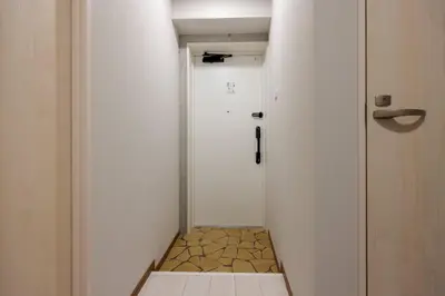 a hallway with a white door and a tile floor at \u30f4\u30a3\u30f3\u30c6\u30fc\u30b8CiTY\u62bc\u4e0a in Tokyo