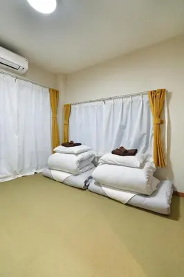a room with three stacks of white pillows in front of a window at BSY401 Ueno Kozuki 401, walk to Ueno shopping district, play in the center of Tokyo, 3 minutes walk to subway station, high-speed 10G Wi-Fi in Tokyo
