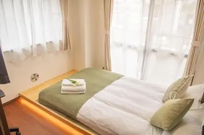 a bed with two towels on it in a bedroom at \u4e1c\u4eac\u90fd\u4e2d\u91ce\u533a in Tokyo