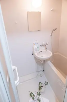 a bathroom with a sink and a toilet with a plant on the floor at \u4e1c\u4eac\u90fd\u4e2d\u91ce\u533a in Tokyo