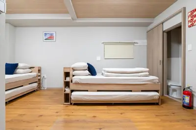 a room with three bunk beds in it at Pagi Hotel in Tokyo