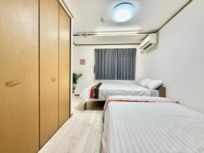 a small room with two beds and a window at Skytree Tokyo Apartment Ohanachaya in Tokyo