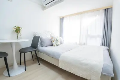 a bedroom with a bed and a table and a window at \u6771\u65b0\u5bbf\u99c5\u5f92\u6b69\u570f \u6b4c\u821e\u4f0e\u753a\u30ca\u30a4\u30c8\u30e9\u30a4\u30d5\u62e0\u70b9\u306e\u30e2\u30c0\u30f3\u5bbf EySi in Tokyo