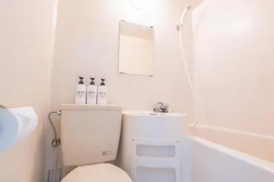 a bathroom with a toilet and a sink and a mirror at \u6771\u65b0\u5bbf\u99c5\u5f92\u6b69\u570f \u6b4c\u821e\u4f0e\u753a\u30ca\u30a4\u30c8\u30e9\u30a4\u30d5\u62e0\u70b9\u306e\u30e2\u30c0\u30f3\u5bbf EySi in Tokyo