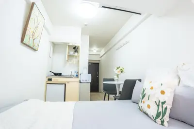 a bedroom with a white bed and a kitchen at \u6771\u65b0\u5bbf\u99c5\u5f92\u6b69\u570f \u6b4c\u821e\u4f0e\u753a\u30ca\u30a4\u30c8\u30e9\u30a4\u30d5\u62e0\u70b9\u306e\u30e2\u30c0\u30f3\u5bbf EySi in Tokyo