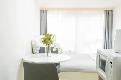 a room with a table with a vase of flowers on it at \u6771\u65b0\u5bbf\u99c5\u5f92\u6b69\u570f \u6b4c\u821e\u4f0e\u753a\u30ca\u30a4\u30c8\u30e9\u30a4\u30d5\u62e0\u70b9\u306e\u30e2\u30c0\u30f3\u5bbf EySi in Tokyo