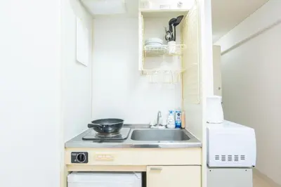 a small kitchen with a sink and a stove at \u6771\u65b0\u5bbf\u99c5\u5f92\u6b69\u570f \u6b4c\u821e\u4f0e\u753a\u30ca\u30a4\u30c8\u30e9\u30a4\u30d5\u62e0\u70b9\u306e\u30e2\u30c0\u30f3\u5bbf EySi in Tokyo