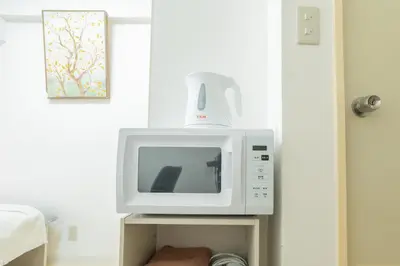 a microwave oven sitting on top of a table at \u6771\u65b0\u5bbf\u99c5\u5f92\u6b69\u570f \u6b4c\u821e\u4f0e\u753a\u30ca\u30a4\u30c8\u30e9\u30a4\u30d5\u62e0\u70b9\u306e\u30e2\u30c0\u30f3\u5bbf EySi in Tokyo