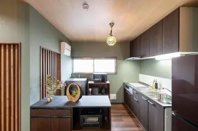a kitchen with wooden cabinets and a counter top at 長期割がお得 最大12名 2BR 70平米 東京駅電車10分 TDR スカイツリー好アクセス 駐車場予約 送迎有 HOTEL DREAM MUSIC Tōyōchō japanese-modern in Tokyo