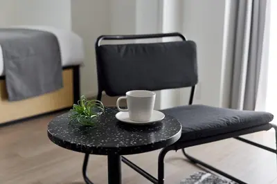 a black chair with a coffee cup on a table at \u30a2\u30fc\u30d0\u30cd\u30c3\u30af\u30b9\u9326\u7cf8\u516c\u5712ll in Tokyo