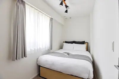a small bedroom with a bed and a window at \u30a2\u30fc\u30d0\u30cd\u30c3\u30af\u30b9\u9326\u7cf8\u516c\u5712ll in Tokyo