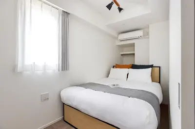 a bedroom with a large bed with a window at \u30a2\u30fc\u30d0\u30cd\u30c3\u30af\u30b9\u9326\u7cf8\u516c\u5712ll in Tokyo