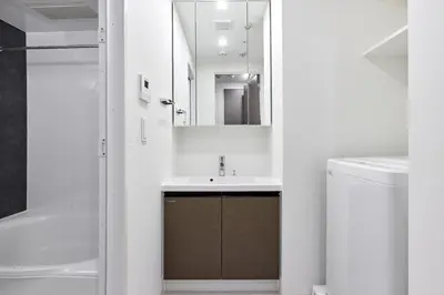 a white bathroom with a sink and a mirror at \u30a2\u30fc\u30d0\u30cd\u30c3\u30af\u30b9\u9326\u7cf8\u516c\u5712ll in Tokyo