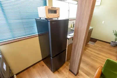 a refrigerator with a microwave on top of it at 長期ステイ歓迎 ポップ ディズニー風 TDR スカイツリー好アクセス 定員3名 東京駅10分 駐車場予約 送迎有 HOTEL DREAM MUSIC Tōyōchō japanese-pop in Tokyo