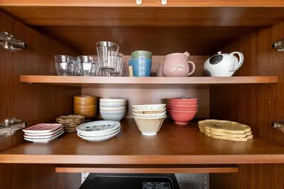 a shelf with bowls and other dishes on it at 長期ステイ歓迎 ポップ ディズニー風 TDR スカイツリー好アクセス 定員3名 東京駅10分 駐車場予約 送迎有 HOTEL DREAM MUSIC Tōyōchō japanese-pop in Tokyo