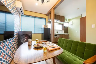 a living room with a table and a green couch at 長期ステイ歓迎 ポップ ディズニー風 TDR スカイツリー好アクセス 定員3名 東京駅10分 駐車場予約 送迎有 HOTEL DREAM MUSIC Tōyōchō japanese-pop in Tokyo