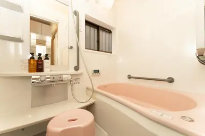 a bathroom with a pink tub and a sink at Skytree Tokyo House Takasago in Tokyo