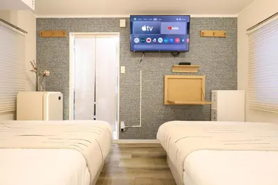 a hospital room with two beds and a tv on the wall at C's Tiny House , 2 double beds , smart stay , near Tokyo Skytree in Tokyo