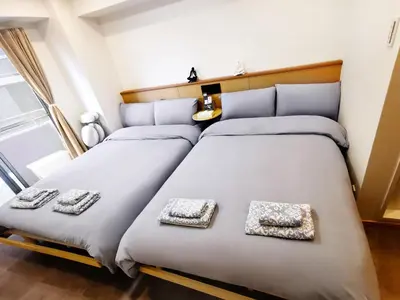 two beds in a small room with two towels at Fukuda House Shinjuku in Tokyo