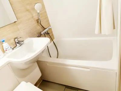 a bathroom with a sink and a toilet and a tub at Fukuda House Shinjuku in Tokyo