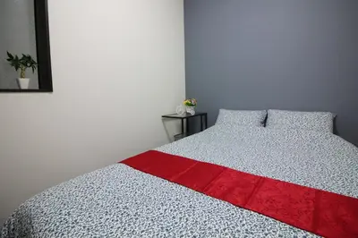 a bedroom with a bed with a red blanket on it at New Up to 10 people OK! 30-second walk from the station exit! Superhosts are here to help you in a polite and prompt manner! Rest assured stay! in Tokyo