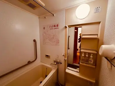 a bathroom with a bath tub and a mirror at ViVo\u9280\u5ea7 in Tokyo