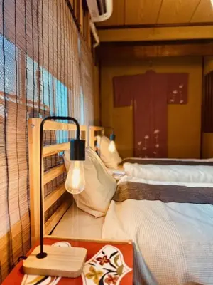 a room with two beds and a table with a lamp at ViVo\u9280\u5ea7 in Tokyo