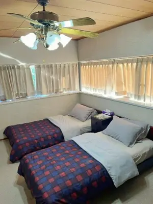 a bedroom with two beds and a ceiling fan at Japan Harry Potter Guesthouse in Tokyo