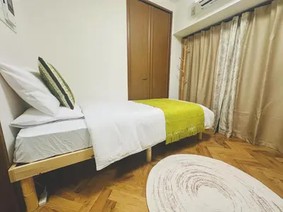 a bedroom with a bed with a yellow and white blanket at 4min to \u6771\u65b0\u5bbfShinjuku in Tokyo