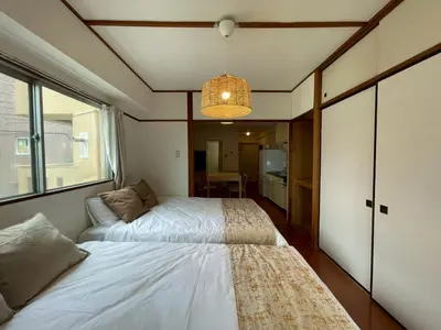 a small bedroom with two beds and a chandelier at Shibuya myroom in Tokyo
