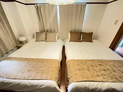 two beds sitting next to each other in a room at Shibuya myroom in Tokyo