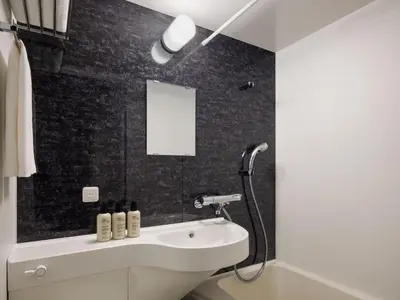 a bathroom with a white sink and a black wall at Four Points Flex by Sheraton Tokyo Higashi Kanda in Tokyo