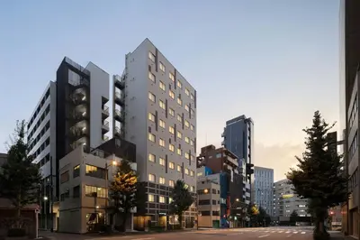 a tall building in a city at dusk at Four Points Flex by Sheraton Tokyo Higashi Kanda in Tokyo