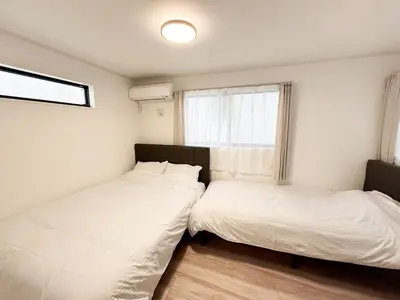 two beds in a small room with a window at Shinjuku Area 3 Bedroom House in Tokyo