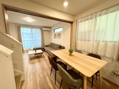 a living room with a wooden table and chairs at Shinjuku Area 3 Bedroom House in Tokyo