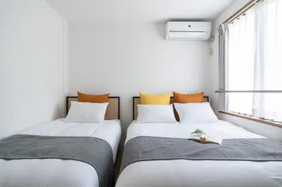two beds sitting next to each other in a room at mt \u4e2d\u91ce\u30d3\u30eb in Tokyo