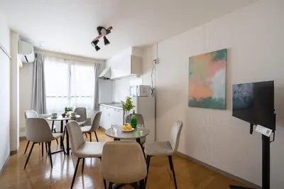 a living room with a table and chairs and a kitchen at mt \u4e2d\u91ce\u30d3\u30eb in Tokyo
